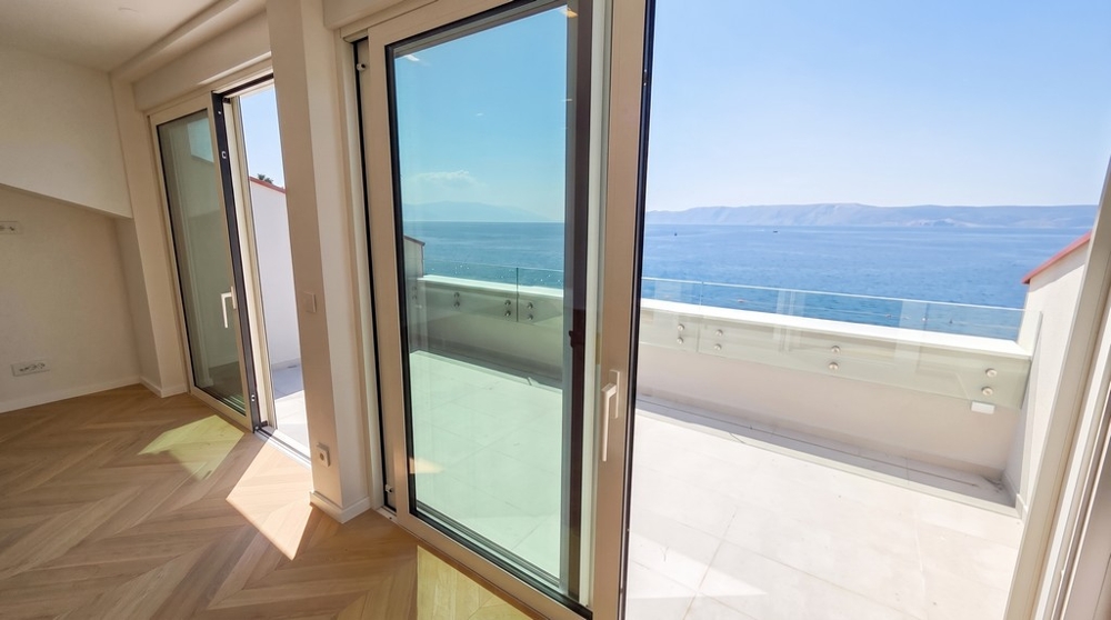 Utsikt genom glasdörrarna till terrassen och havet