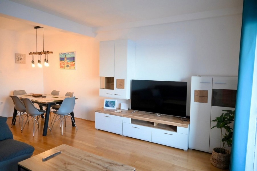 Vardagsrum med matbord och TV-vägg