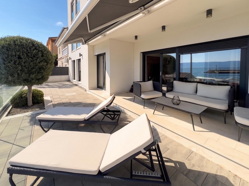 Solterrass med solstolar och utsikt över havet i Kroatien