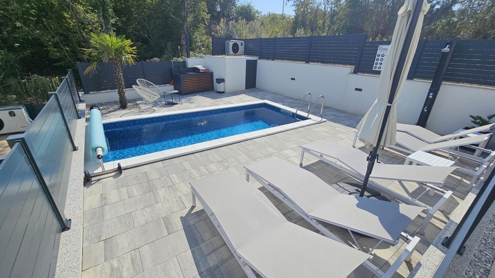 Pool och solterrass i lägenhetens egen trädgård i Malinska
