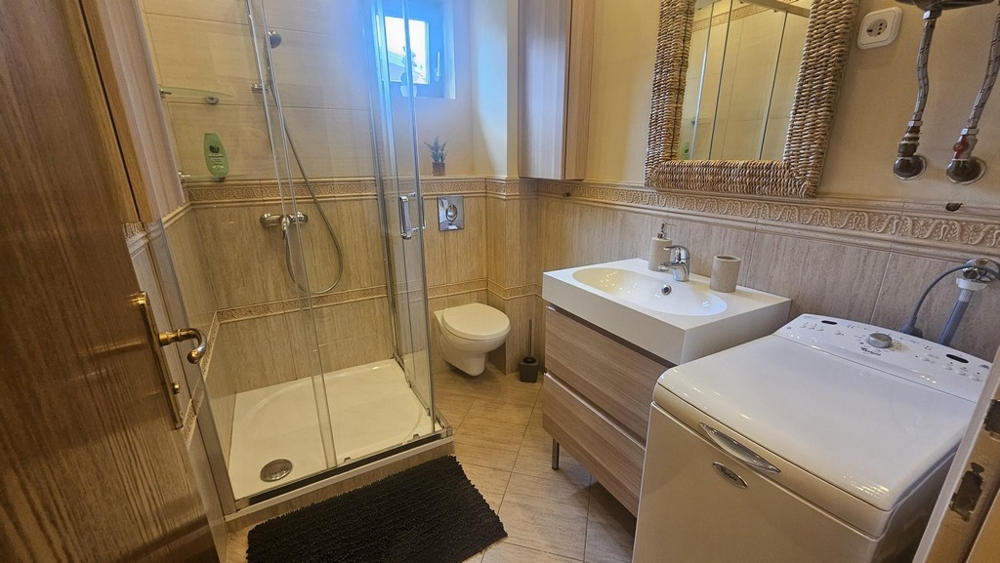 Badrum med dusch, toalett och tvättmaskin