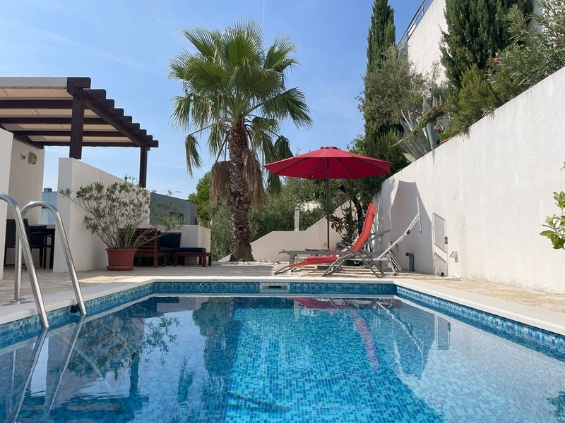 Gemensam pool med palmer i bostadskomplexet i Murter
