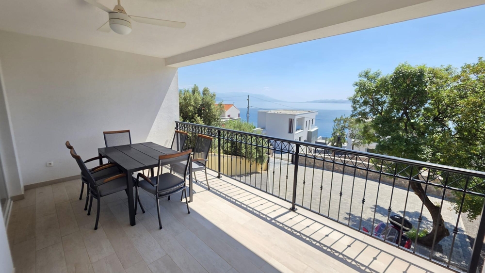 Loggia med matbord och utsikt över havet