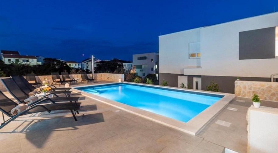Pool i bostadskomplexet i Novalja på kvällen