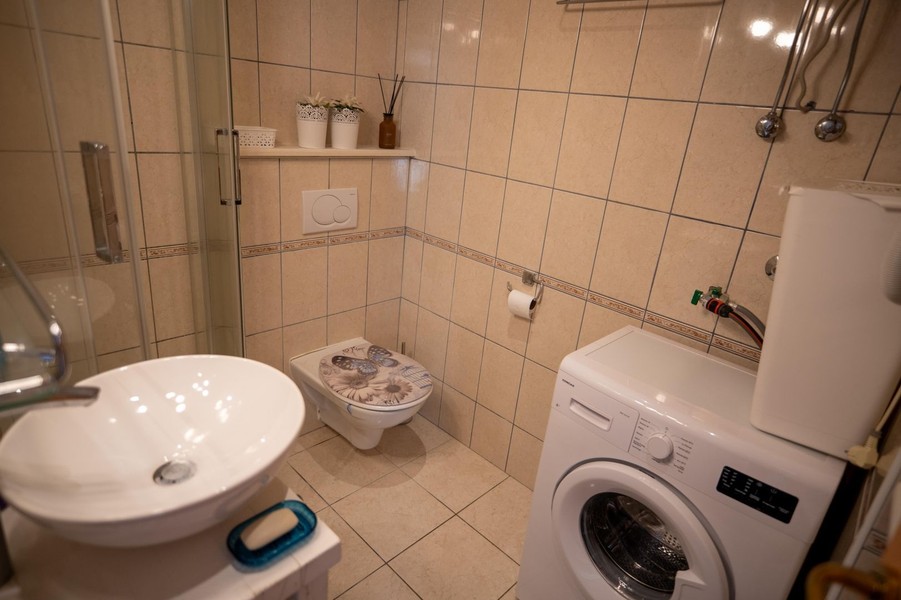 Badrum med dusch och tvättmaskin