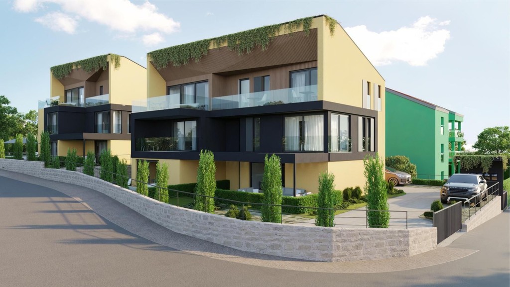 Nybyggda hus med glasbalkonger och grönklädda takkanter längs gatan