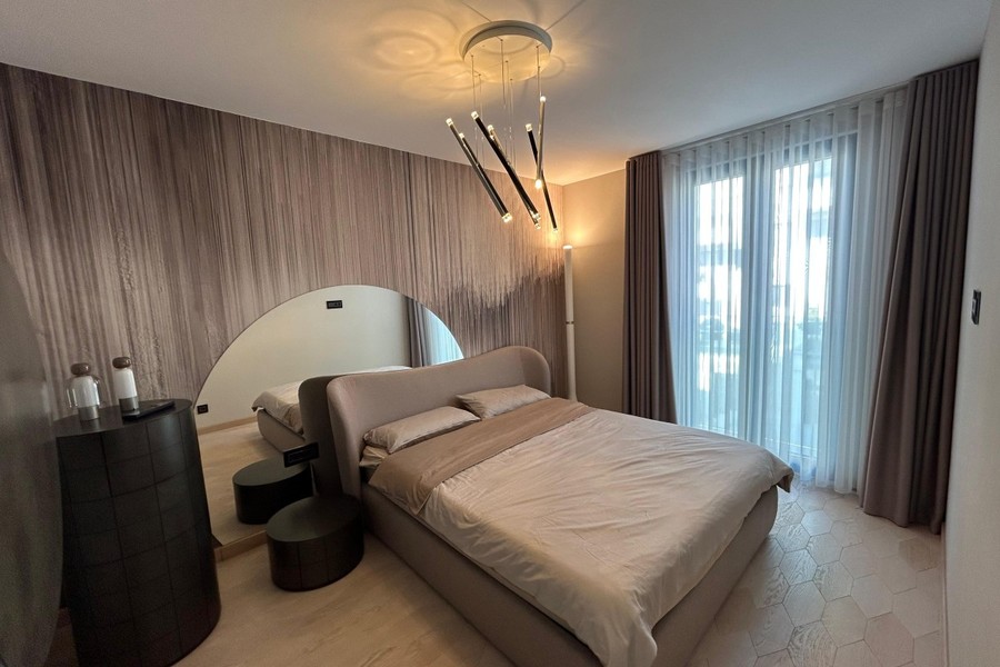 Sovrum med kläddsäng och designerlampa
