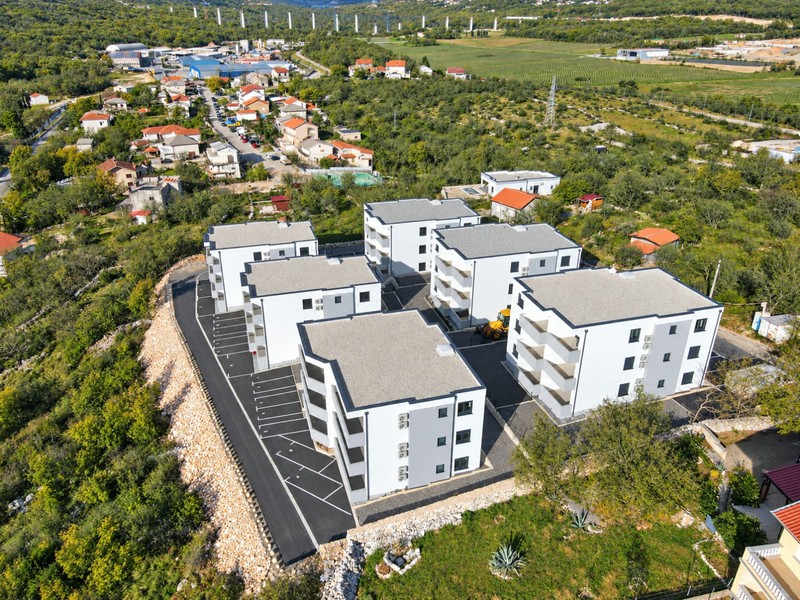 Nybyggda hus i sluttningen med parkeringsplatser
