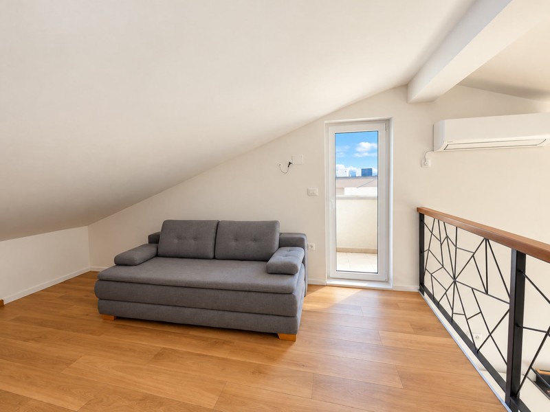 Galleri med bäddsoffa och balkongdörr