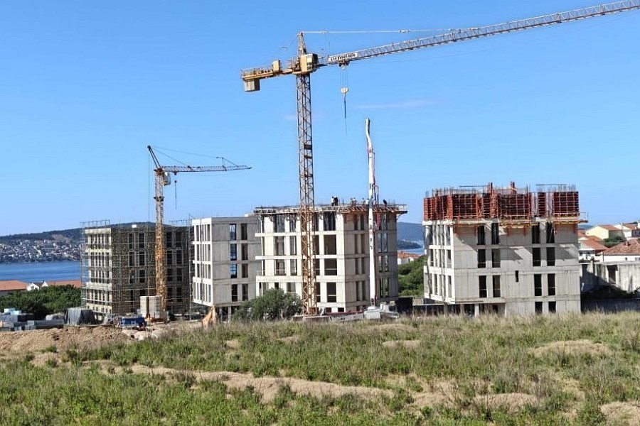 Byggarbetsplats för bostadsanläggningen med utsikt över viken vid Trogir