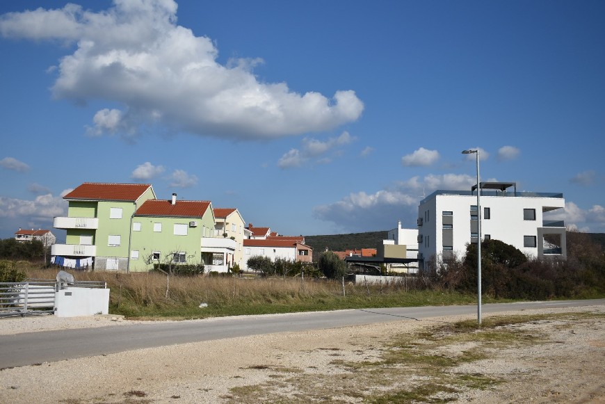 Utsikt över tillfartsväg, fastighet och grannhus
