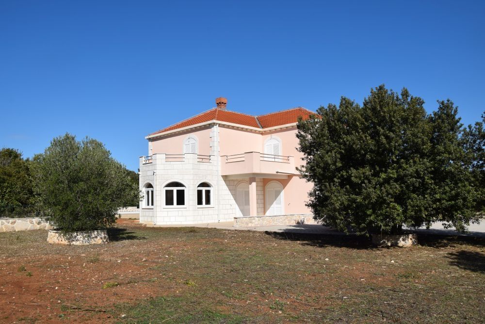 En stor trädgård omger villan.