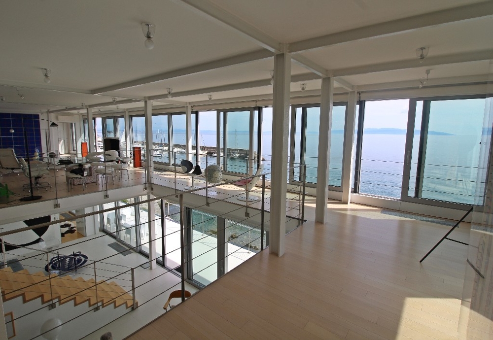 Inomhusområde med utsikt över havet och poolen.