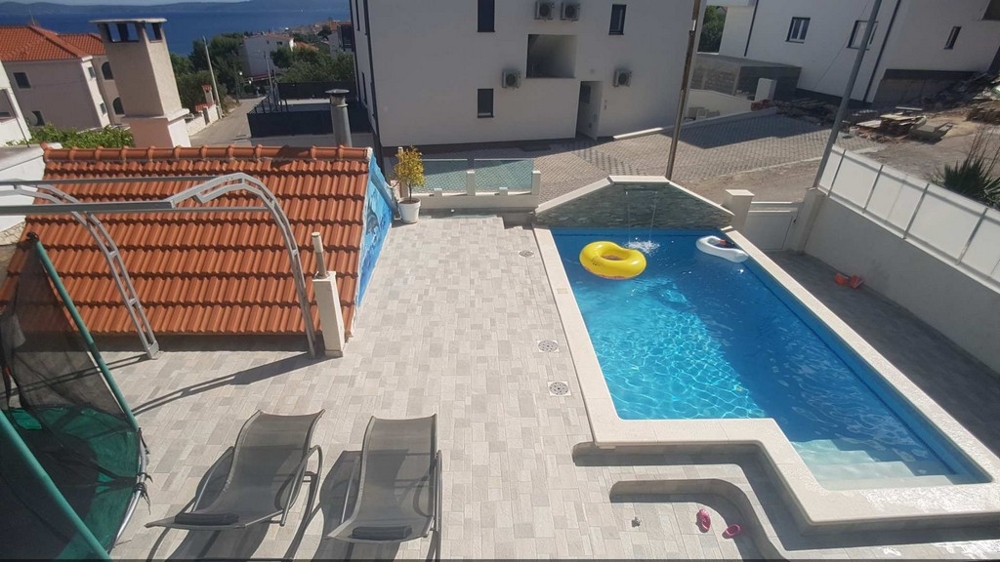 Utsikt från en balkong över terrassen och poolen