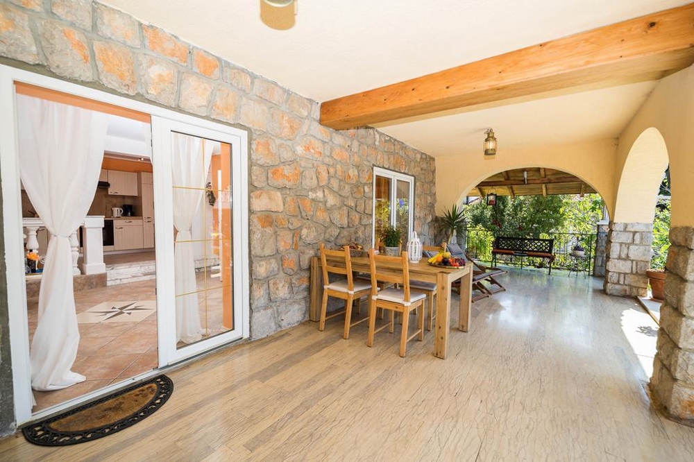 Annat perspektiv på altanen med utsikt över huset och trädgården