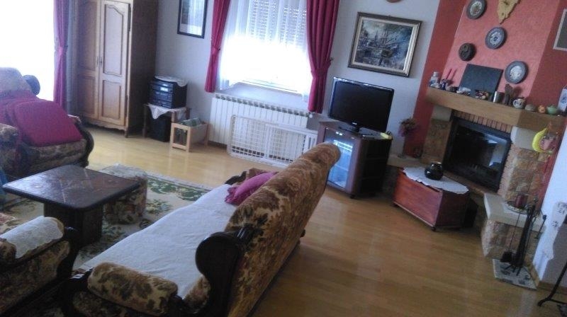 Möblerat vardagsrum med öppen spis.