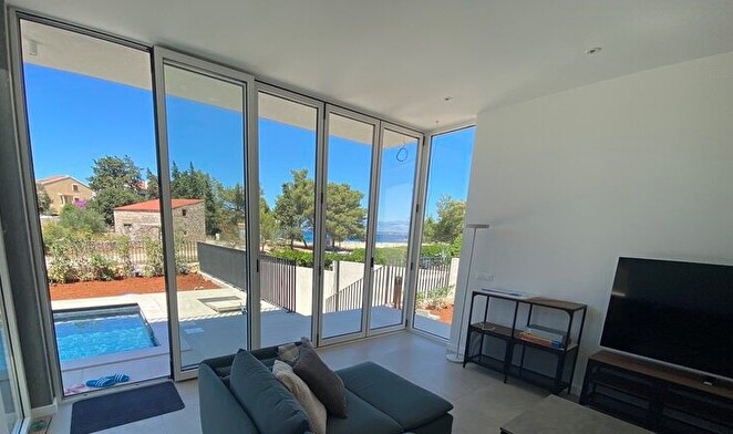 Vardagsrum med utsikt över poolen.