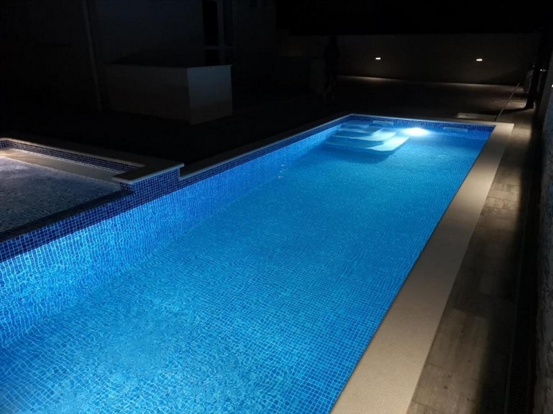 Modernt och funktionellt inrett kök med vardagsrum och matplats.