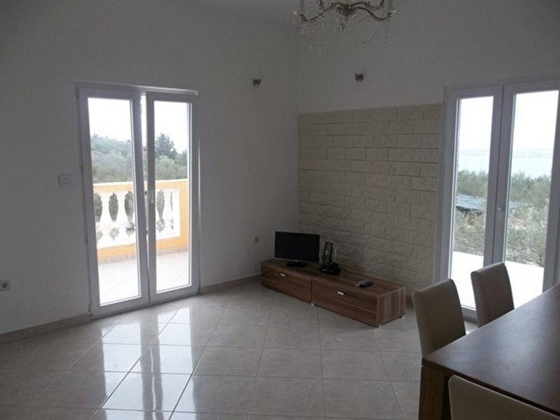 Vardagsrum med utsikt över de gröna omgivningarna.