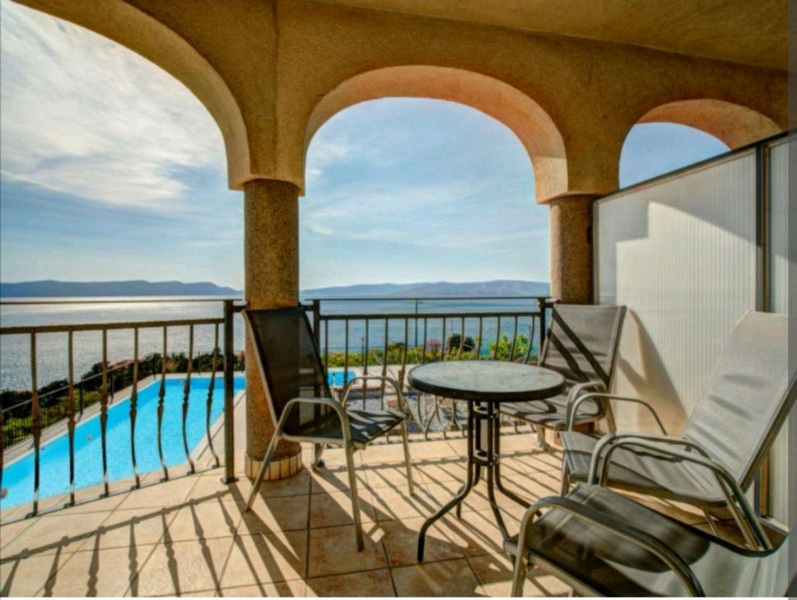 Pool och havsutsikt från den täckta terrassen på övervåningen.