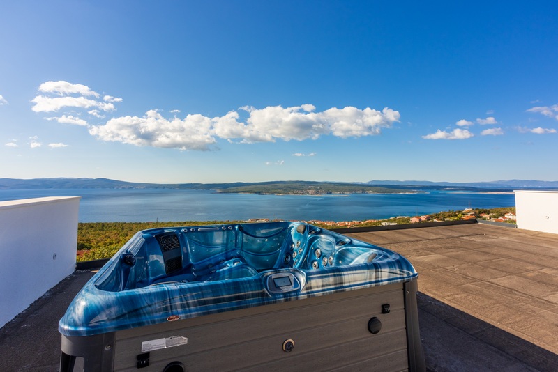 Takterrass med jacuzzi och panoramautsikt över havet.