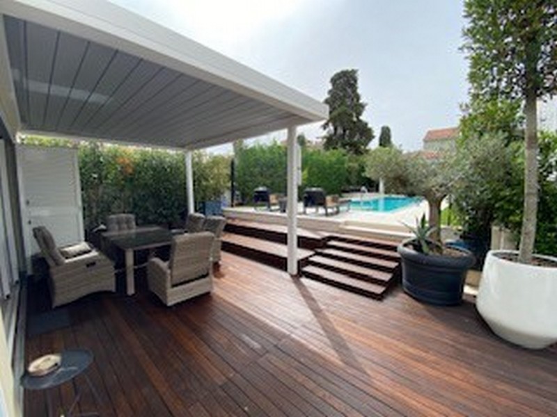 Halvtäckt träterrass med utsikt över poolen i lyxvillan i Istrien till salu.