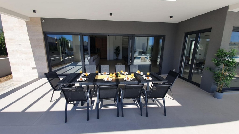 Modern terrass med täckt matplats.