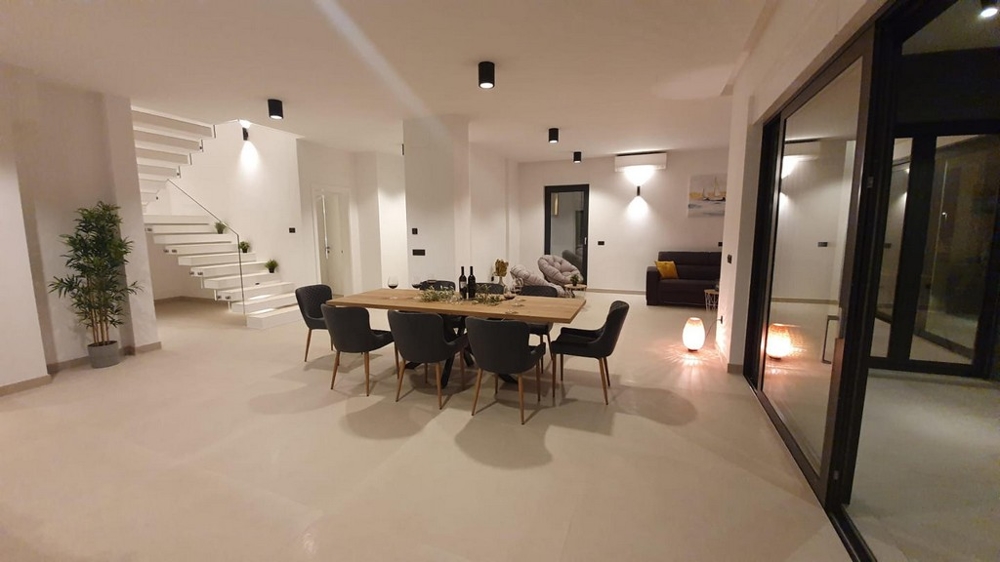 Öppen yta med matbord och utsikt över trapphuset.