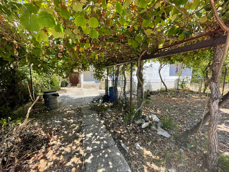 Trädgård och täckt parkeringsplats.