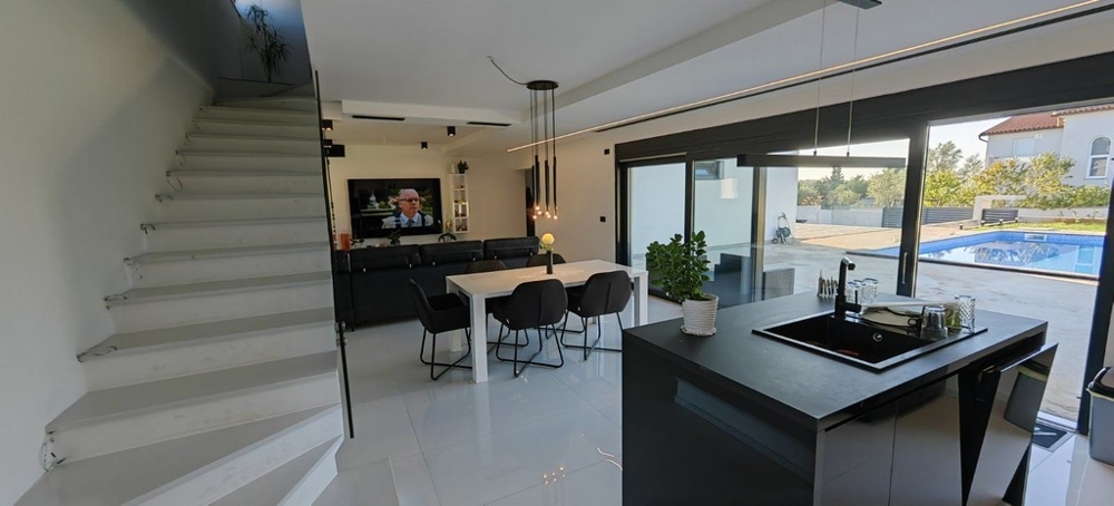 Vardagsrum och utsikt över trappan som leder till övervåningen.