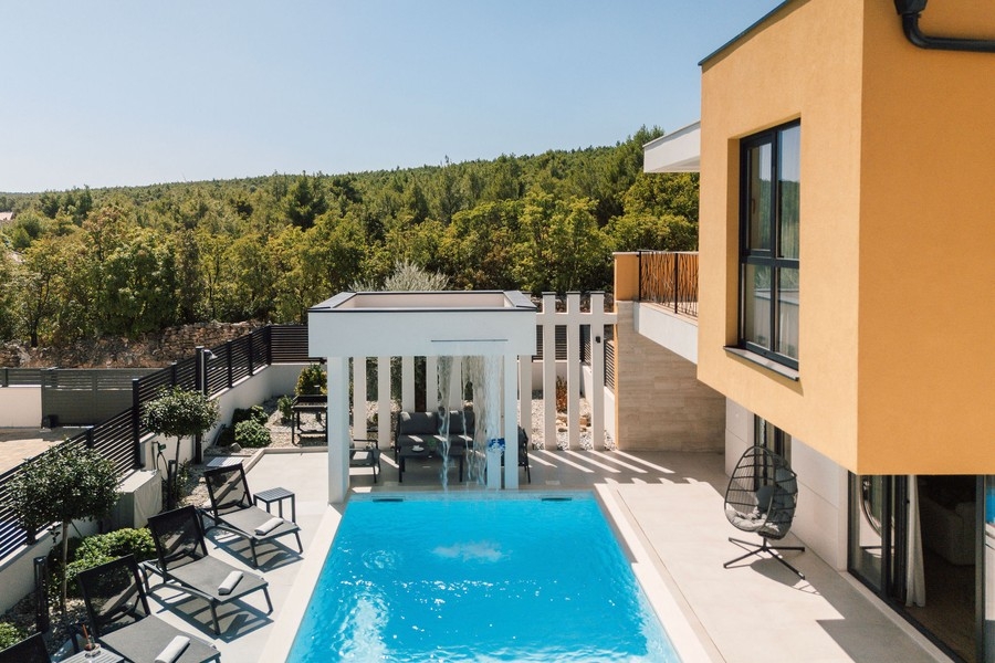 Pool med övertäckt sittplats och utsikt mot grönskan