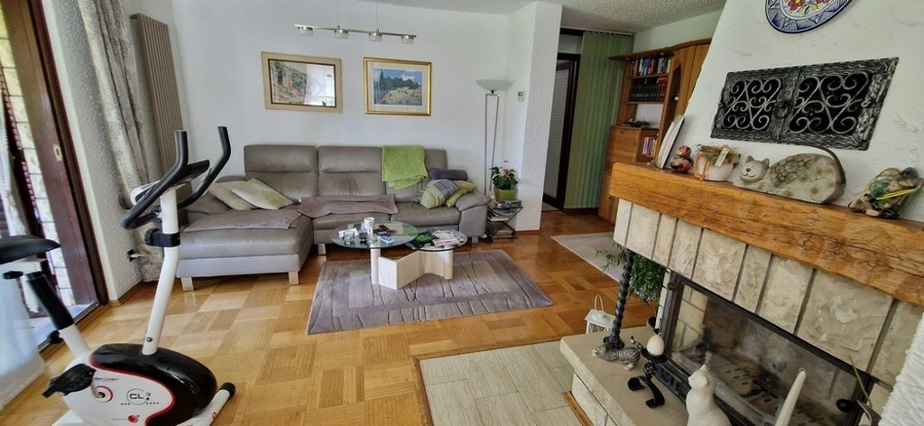 Ljust vardagsrum med utgång till utsidan och öppen spis