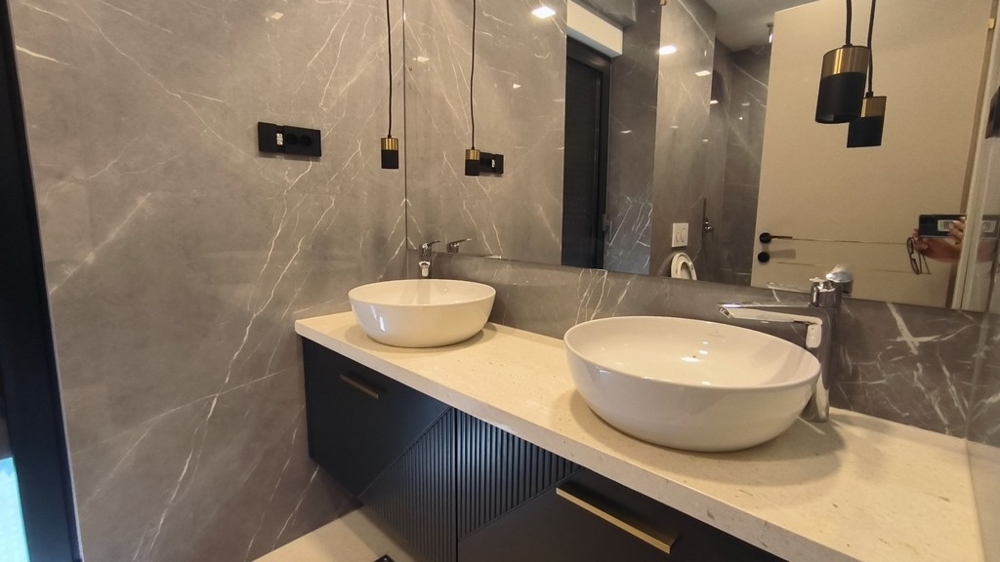 Lyxigt badrum med två handfat och marmorkakel