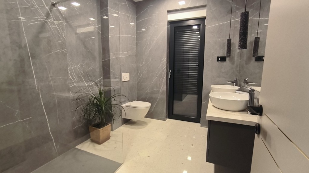 Rymligt badrum med duschkabin och dubbla handfat