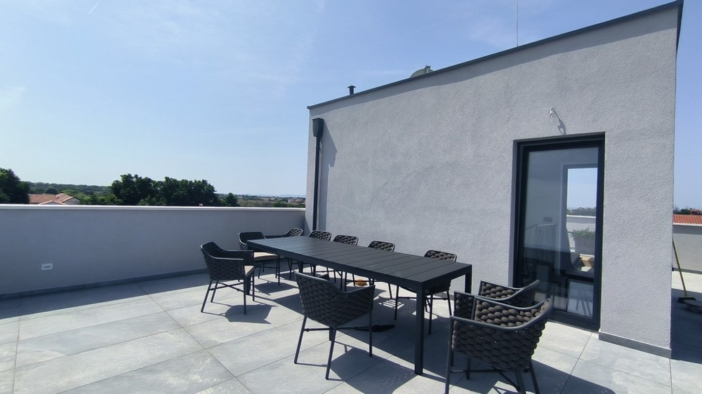 Takterrass med stort matbord och utsikt