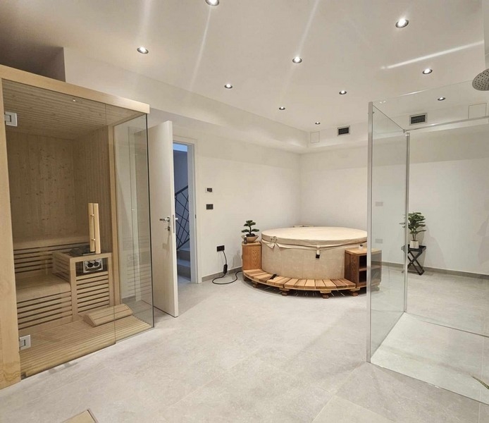 Stor wellnessavdelning med jacuzzi, bastu och dusch.