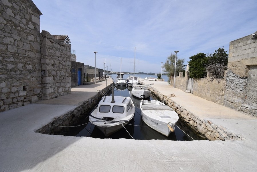 Huset har en liten båt med utombordsmotor.