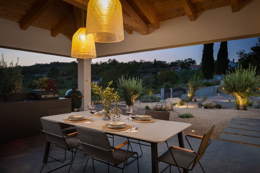 Övertäckt terrass med matbord och stämningsfull belysning