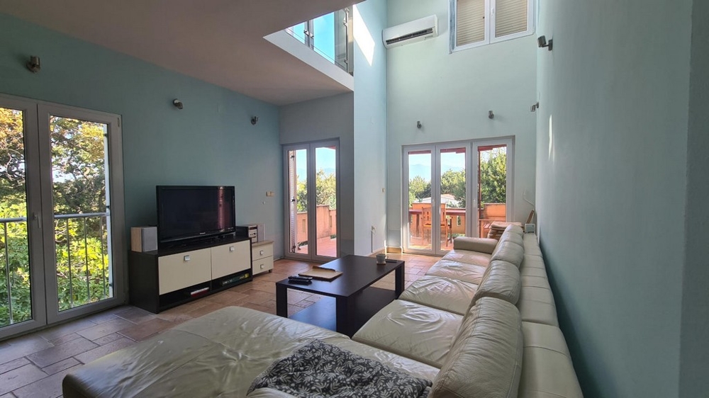 Ljust vardagsrum med utgång till trädgård och terrass