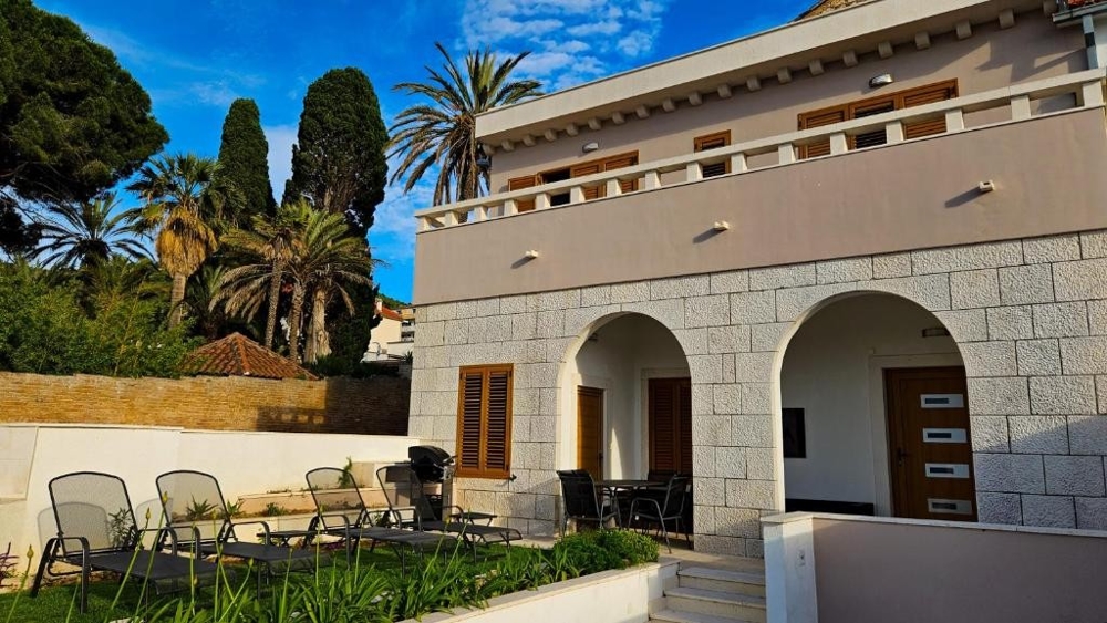 Sovrum med naturstenvägg, stort fönster och utsikt över grön vegetation - Fastigheter Kroatien H2846