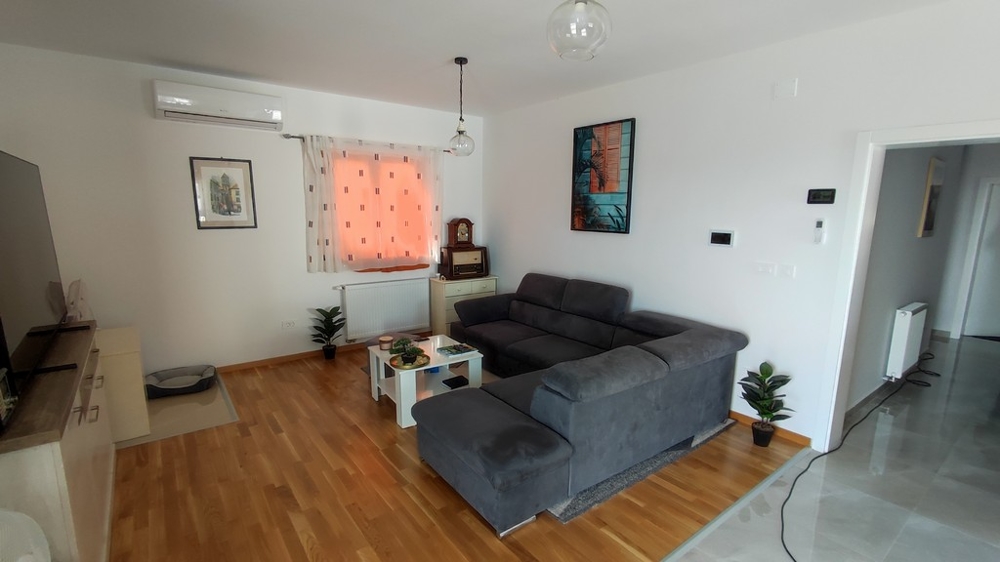 Modernt vardagsrum i hus till salu i Vodice, Kroatien, med eleganta möbler och trägolv.