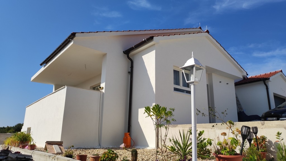 Sidovy av hus till salu i Vodice, Kroatien, med vit fasad och terrass.