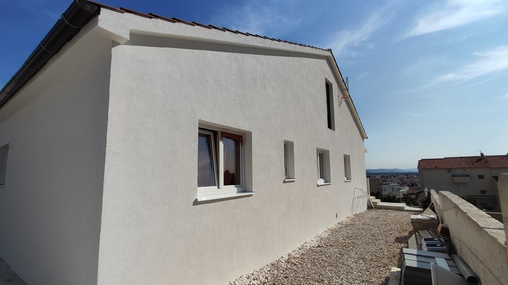 Exteriör sidovy av det fristående huset i Vodice med utsikt över Adriatiska havet, till salu i Kroatien.