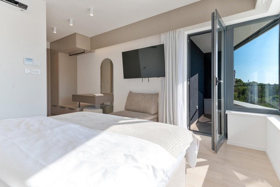 Sovrum i en kroatisk villa till salu med modern design och tillgång till balkong.