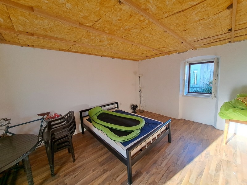 Ljust sovrum med trätak och minimalistisk inredning i en fastighet i Kroatien, tillgängligt via Panorama Scouting.