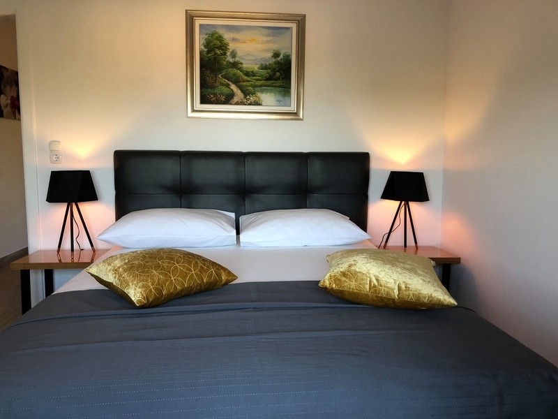 Elegant sovrum med dubbelsäng och målningar i en fastighet i Kroatien