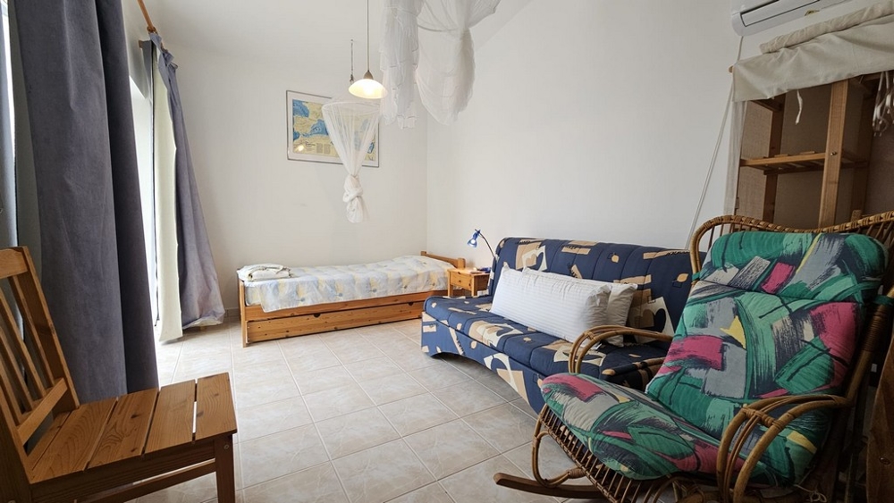 Vardagsrum med bäddsoffa och enkelsäng i hus till salu i Karlobag