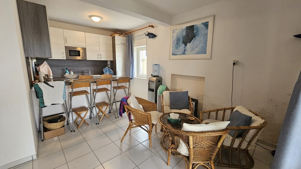 Vardagsrum med sittplatser och öppet kök i huset till salu i Karlobag