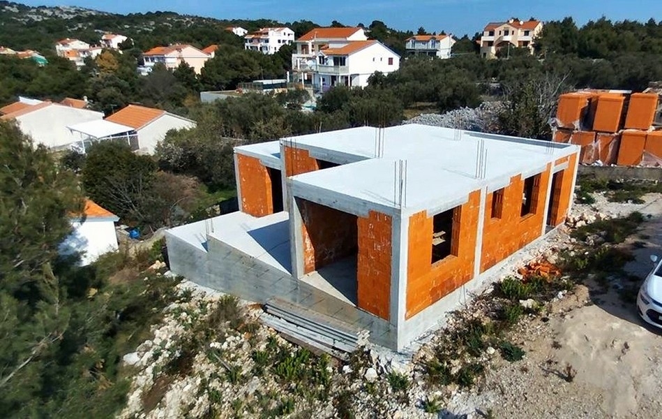 Detaljerad vy av byggandet av en villa med exponerade tegelväggar och betongpelare till salu på ön Krk i Kroatien