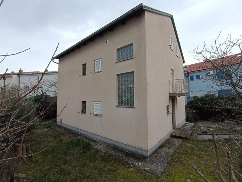 Sidovy av ett hyreshus till salu i Crikvenica, Kroatien, med synligt trädgårdsområde